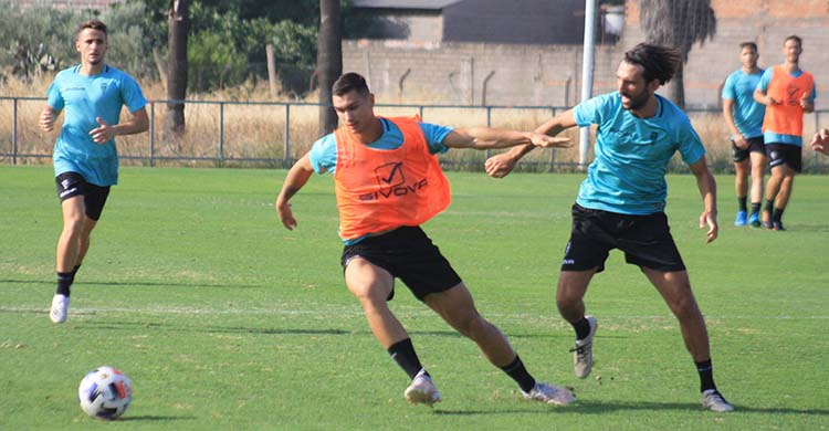 Adrián Fuentes fajándose ante Álex Bernal sobre el verde natural de la Ciudad Deportiva.