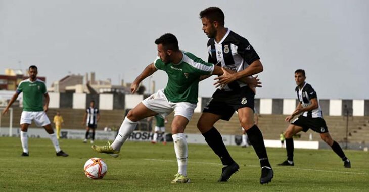 Carlos Puga pisando el balón ante un rival.