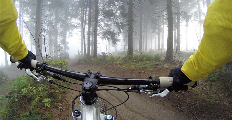 Un ciclista con la vista desde su cámara haciendo mountain bike.