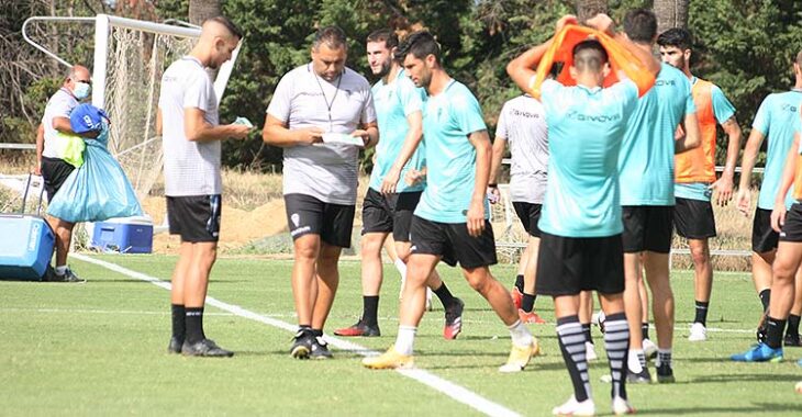 Germán Crespo repasando sus notas junto a Álex Prieto y varios jugadores.