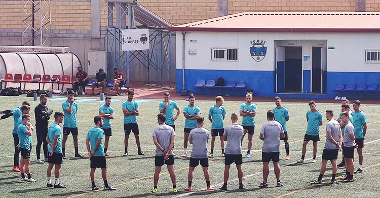 Los expedicionarios blanquiverdes escuchando a Germán Crespo antes de encarar la sesión de entrenamiento sobre el césped artificial del terreno de juego de Las Torres canario.