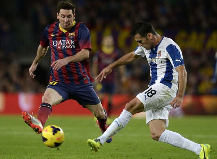 Juan Fuentes perseguido por Messi jugando el derbi catalán.