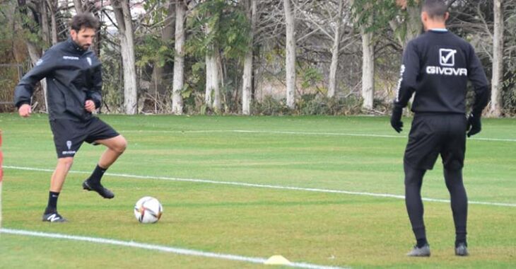 Álex Bernal tocando balón junto a Miguel de las Cuevas trabajando al margen del grupo con el recuperador Javi Poveda.