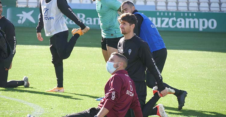 El preparador físico, Álex Prieto, con su mascarilla puesta, con Javi Flores y Miguel de las Cuevas estirando a la conclusión del entrenamiento.