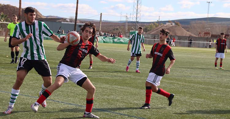 Un jugador del Séneca protege el balón ante la presión de un juvenil cordobesista.