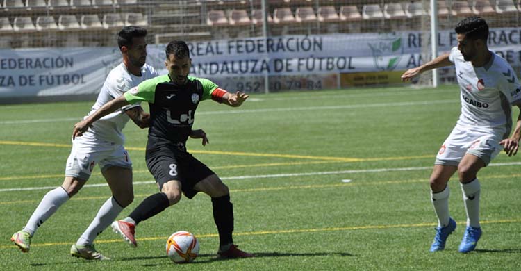 Mario Ruiz entre dos jugadores del Utrera. Foto: Ciudad de Lucena