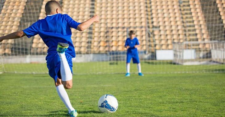 Dos jóvenes futbolistas entrenando.