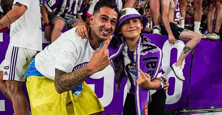 Sergio León celebrando su ascenso a Primera con el Real Valladolid enfundando en la bandera del Atlético Palma del Río.