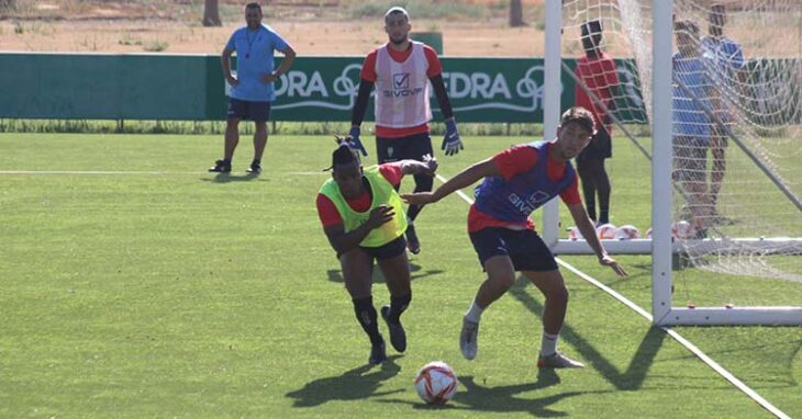 Cedric y Matías Barboza pugnan por un balón con el meta del filial Lluis Tarrés al fondo en su primer entreno de la pretemporada con el primer equipo
