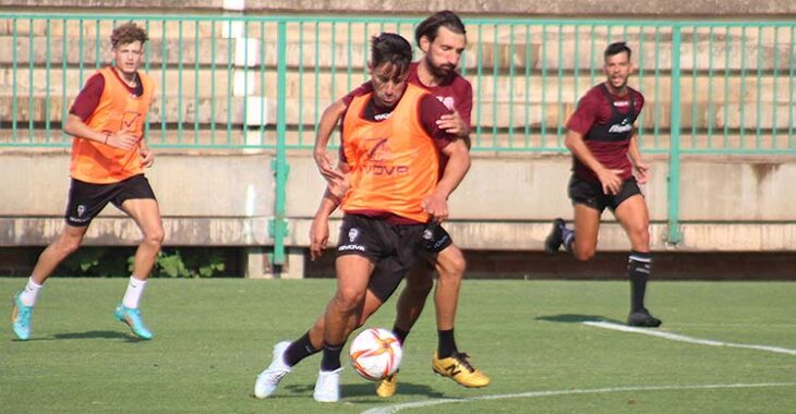 Kike Márquez metiendo el cuerpo ante Álex Bernal para proteger el balón.