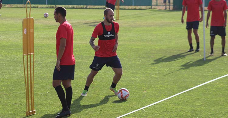 Sergio Benito circulando el balón a las espaldas de Miguel de las Cuevas.