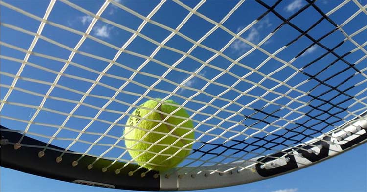 Una raqueta de tenis con una pelota antes del servicio.