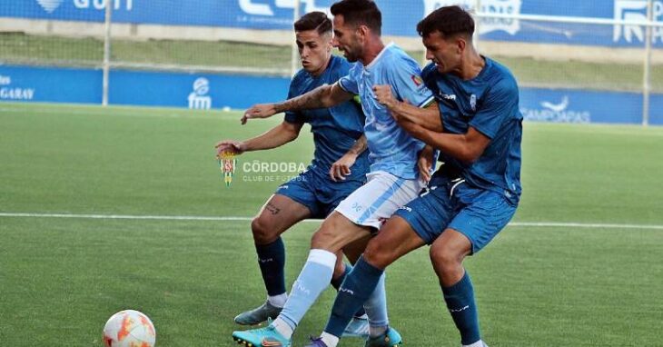 Disputa del balón entre dos jugadores del Córdoba B y uno del Ciudad de Lucena