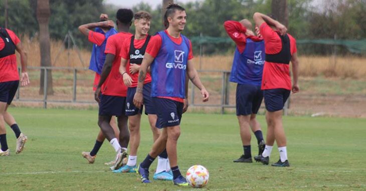 Cristian Carrracedo sonríe con el balón en los pies y Simo a sus espaldas.