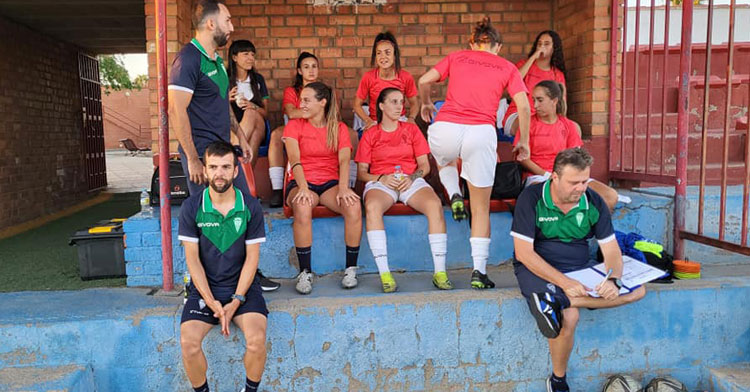 Fran Rodríguez sentado en el banquillo junto a las jugadoras del Córdoba Femenino
