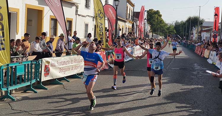 Varios atletas entrando victoriosos en la línea de meta de la Media de Almodóvar.