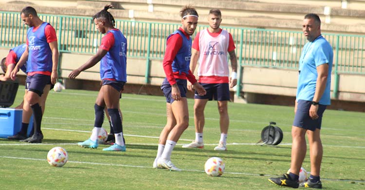 Gudelj mirando a Germán Crespo en la vuelta a los entrenamientos.