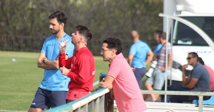 Javi Flores refrescándose en la banda junto al doctor Escribano, con Juanito y Raúl Cámara al fondo.