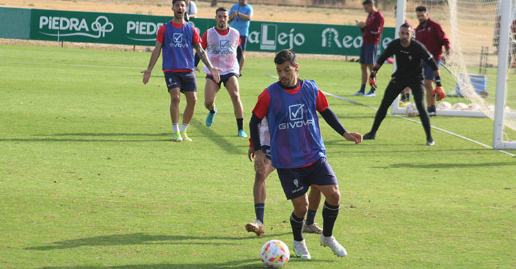 José Ruiz protege el balón ante un compañero durante el entrenamiento con Willy pidiendo el balón al fondo.