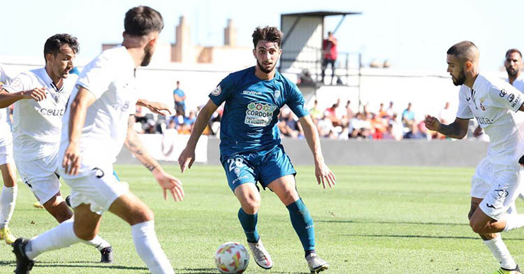 Christian Delgado con el balón en los pies rodeado por tres jugadores del Ceuta.