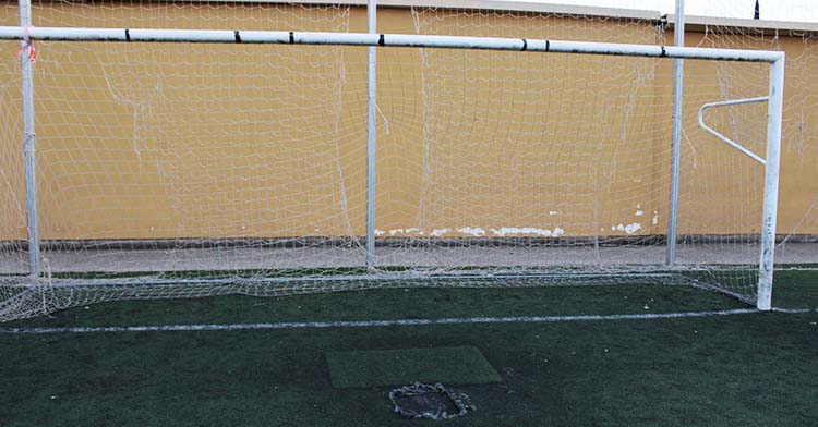 Una de las porterías del campo de fútbol-11. de El Naranjo con el cemento aflorando poco antes de la línea de gol.