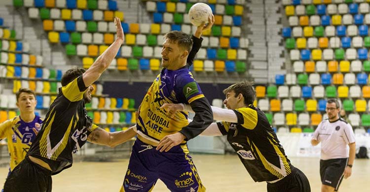 El rumano Andy Buzzle armando el brazo entre dos jugadors del Alarcos.