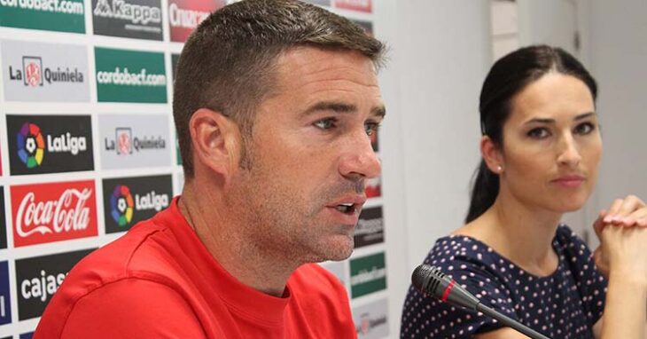 Luis Carrión en su segunda etapa como entrenador del Córdoba en la sala de prensa de El Arcángel con la dircom blanquiverde, Marian Saco, de fondo.