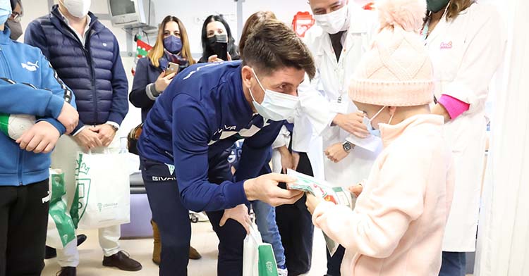Javi Flores entregando un regalo a un niño hospitalizado en el Reina Sofía.
