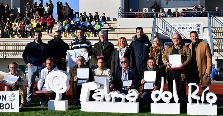 La alcaldesa de Palma del Río, Esperanza Caro de la Barrera, juntos a los monitores homenajeados en la inauguración del campo de césped artificial.