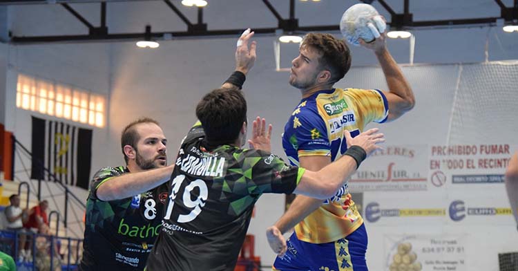 David Estepa armando el brazo ante dos jugadores del Torrelavega en el partido de la primera vuelta.