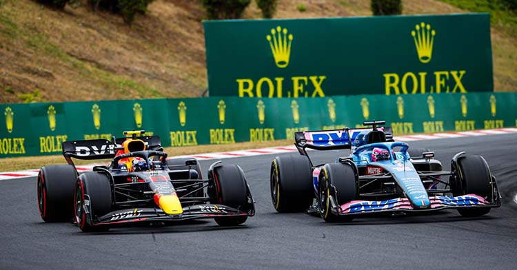 Fernando Alonso y Sergio Pérez trazando una curva en un circuito de Fórmula 1.