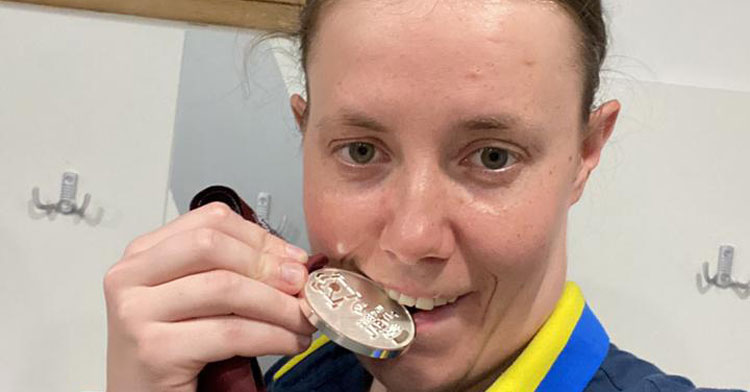 Natali mordiendo su medalla de plata