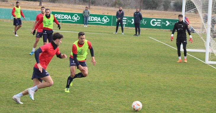 Marco Camus busca un balón dividido junto a Antonio Caballero.