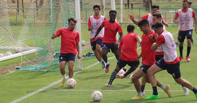 Juan Villar trata de arrebatarle el balón a Willy, con otras disputas de balón al fondo entre el resto jugadores del plantel.