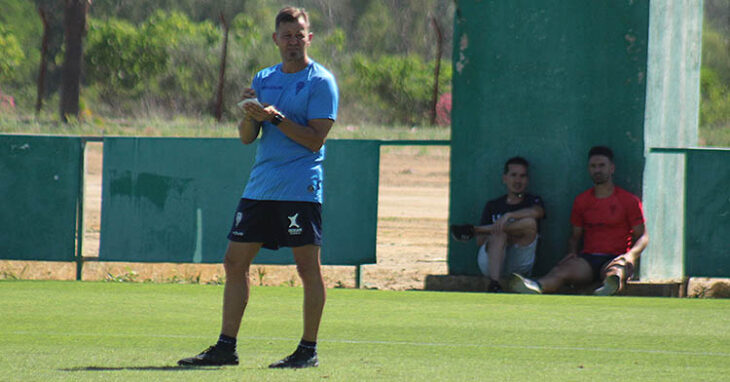 Kike Márquez, sentado a la sombra al fondo junto al responsable de comunicación del club, en uno de los últimos entrenamientos de la temporada.