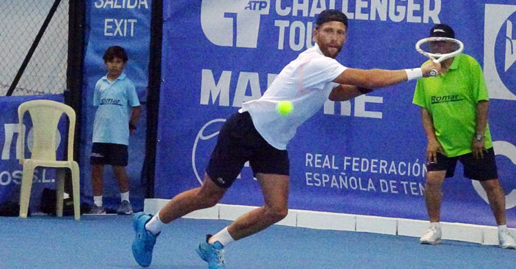 Hugo Grenier tratando de devolver una bola desde el fondo de la pista