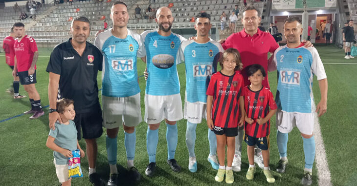 Juanmi Puentenueva, entrenador del Salerm Puente Genil, posa con varios jugadores del Écija CF que tuvo a sus órdenes otras temporadas al acabar el partido