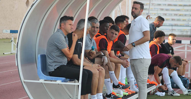 Iván Ania sentando en el banquillo del Iberoamericano junto a su cuerpo técnico.