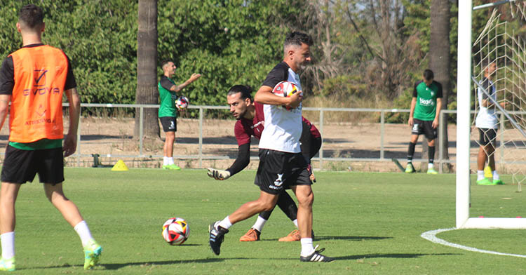 Iván Ania reflexionando en mitad del entrenamiento con Lluis Tarrés al fondo.