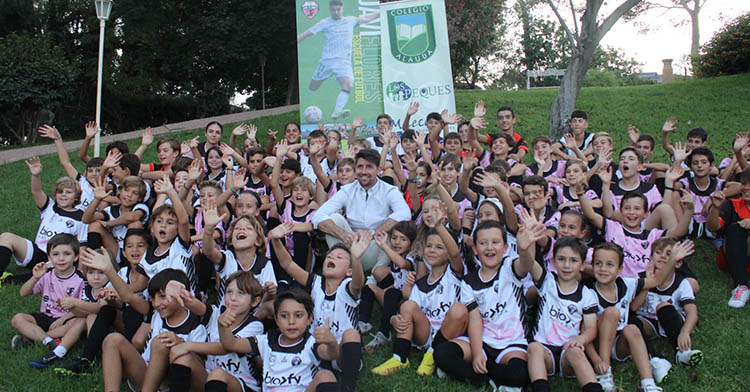 Javi Flores rodeados de los niñ@s de la escuela que lleva su nombre en los jardines del Colegio Alauda.