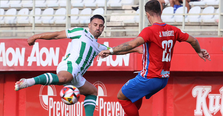 Kike Márquez empalando el balón ante un zaguero del Algeciras.