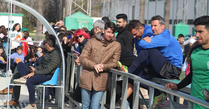 Javi Flores charlando con Gaspar y Sebas, rodeado de los alumnos del Colegio Salvador Vinuesa, con Jiuanito y Antonio Fernández Monterrubiio a la izquierda en el banquillo siguiendo el entrenamiento.