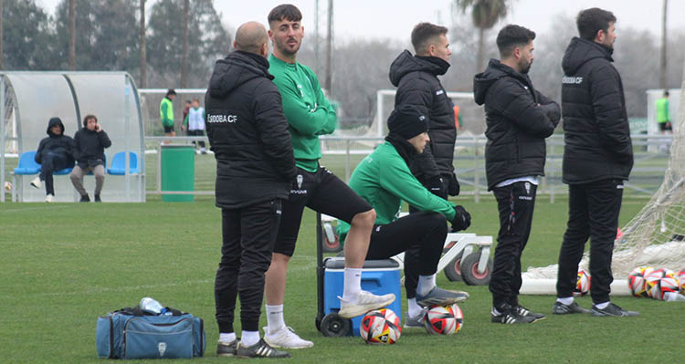 Álex Sala sentado sobre una nevera durante el entrenamiento de este martes con Adri castellano de pie junto a los fisioterapeutas.
