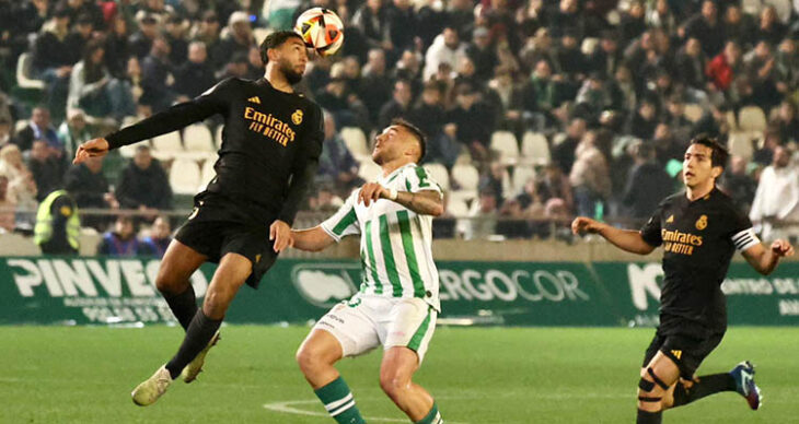 Un zaguero del Real Madrid Castilla despejando de cabeza ante Antonio Casas.