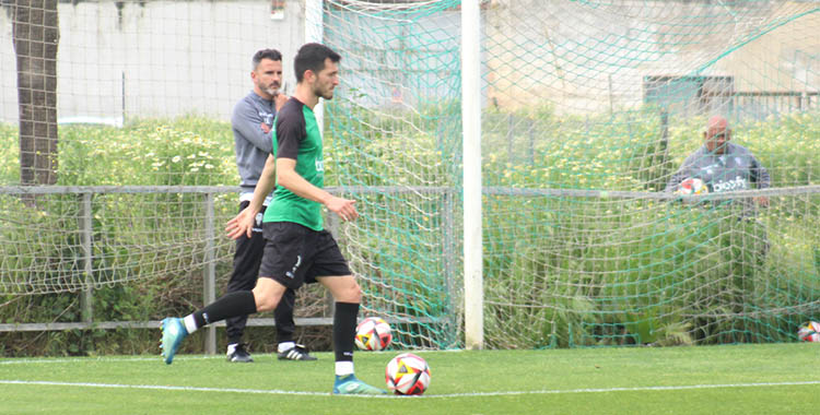 Adri Lapeña saliendo con el balón con Iván Ania al fondo.