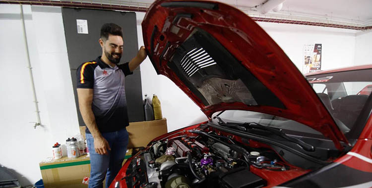 Alfonso Cabello inspeccionando el motor de su coche.