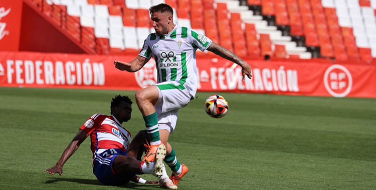 Antonio Casas perdiendo el balón ante un zaguero del Recreativo Granada.