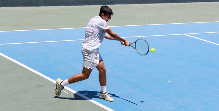 Alejandro López golpeando de revés sobre la pista rápida de Málaga.