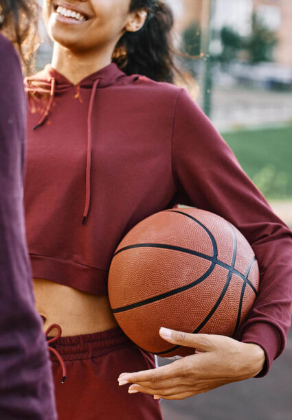 Una chica con un balón de baloncesto antes de un entrenamiento.