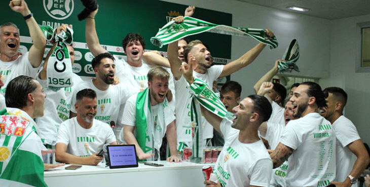 Iván Ania celebrando el ascenso con varios jugadores en la sala de prensa.